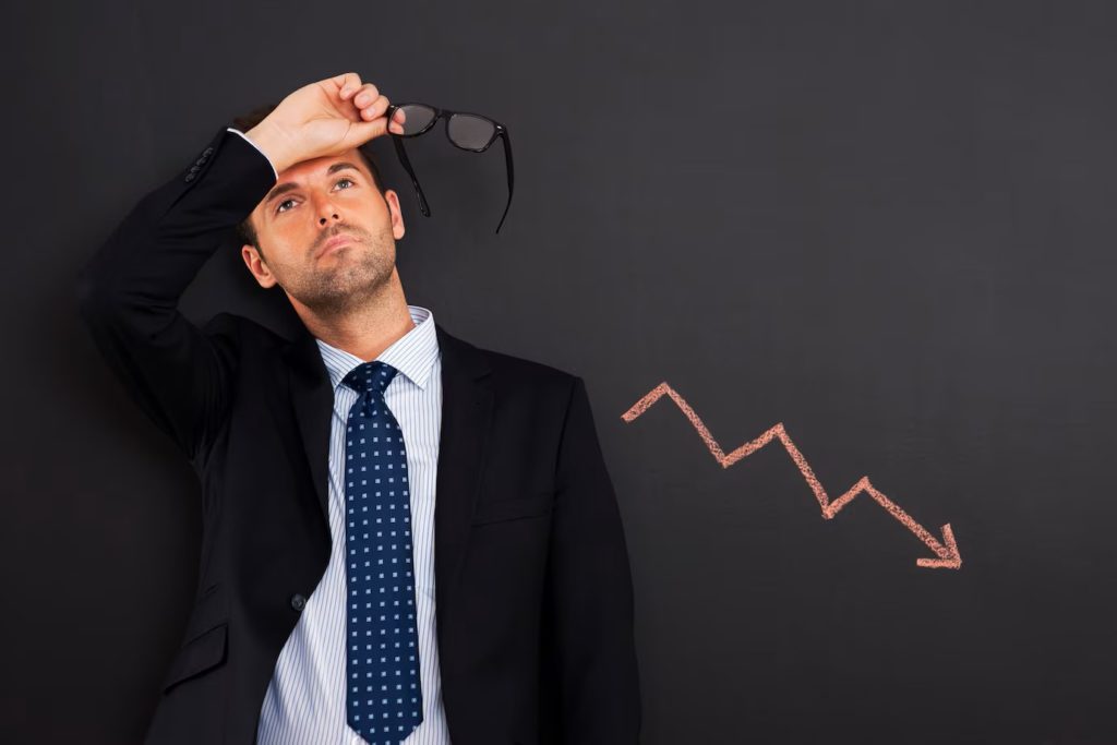 worried-businessman-with-sign-decreased-profit_329181-720